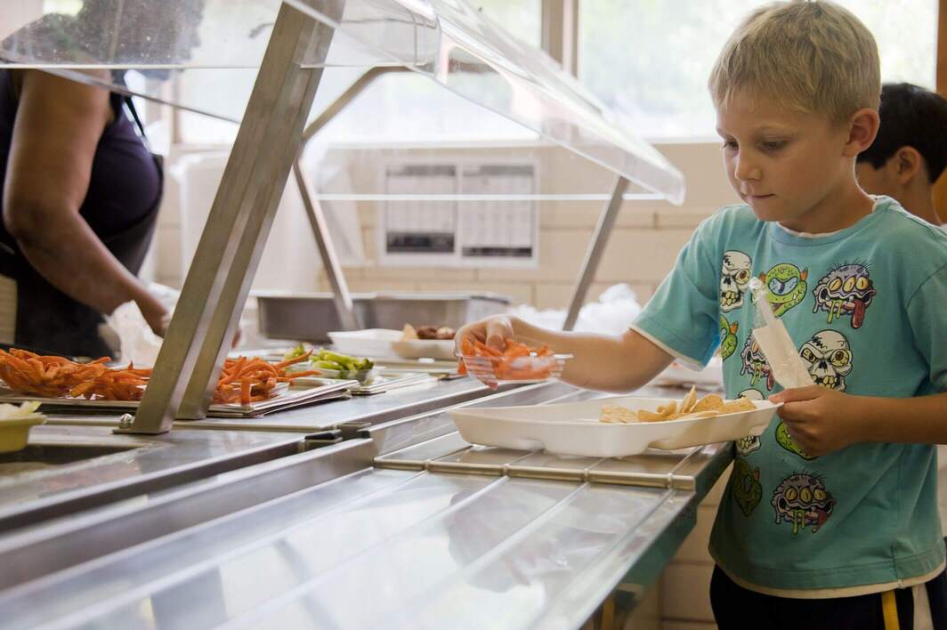 Enfant au buffet de la cantine d'une école.