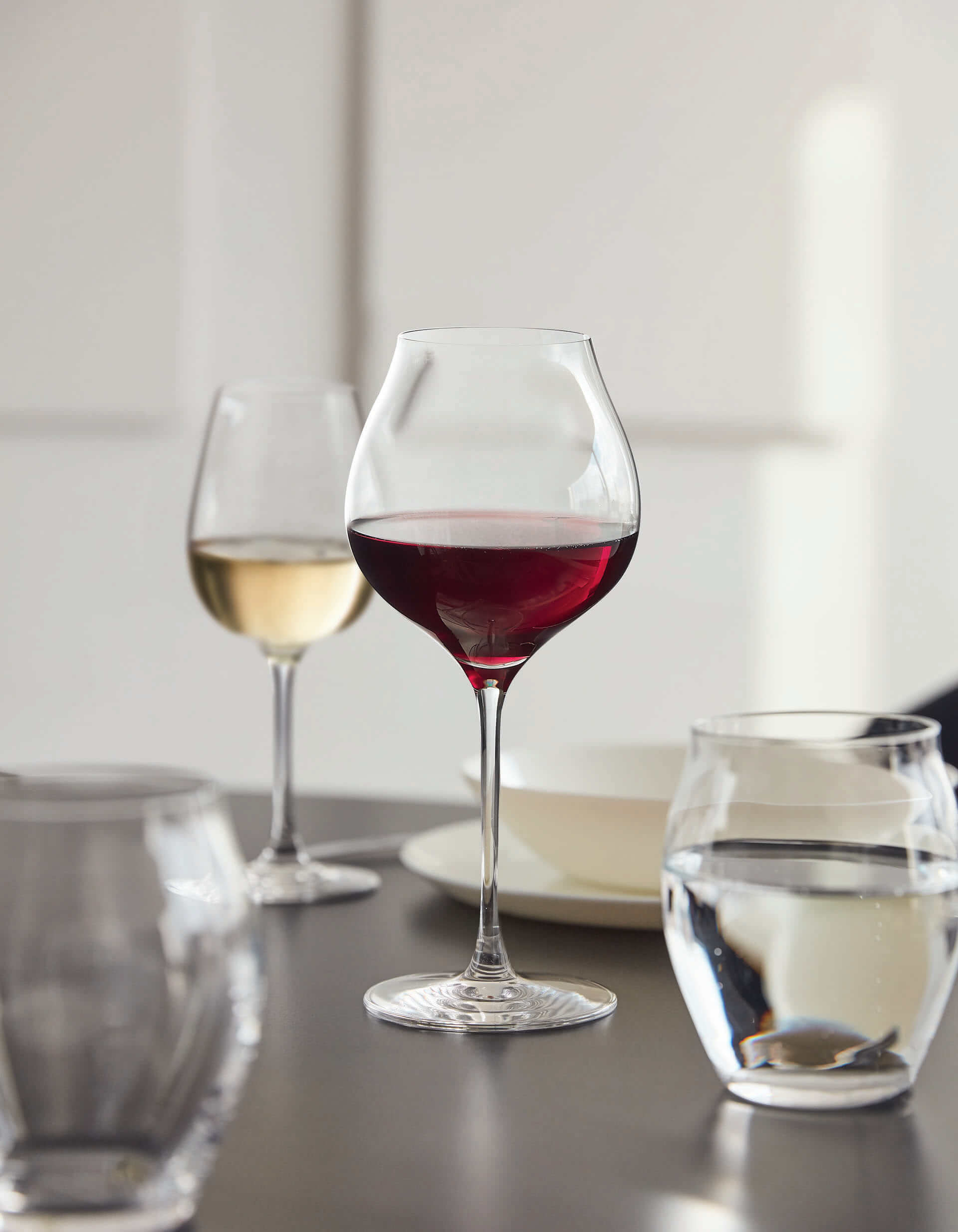 Photo de trois verres : deux verres à vin, l'un à vin rouge l'autre à vin blanc, et un verre à eau sans pied.