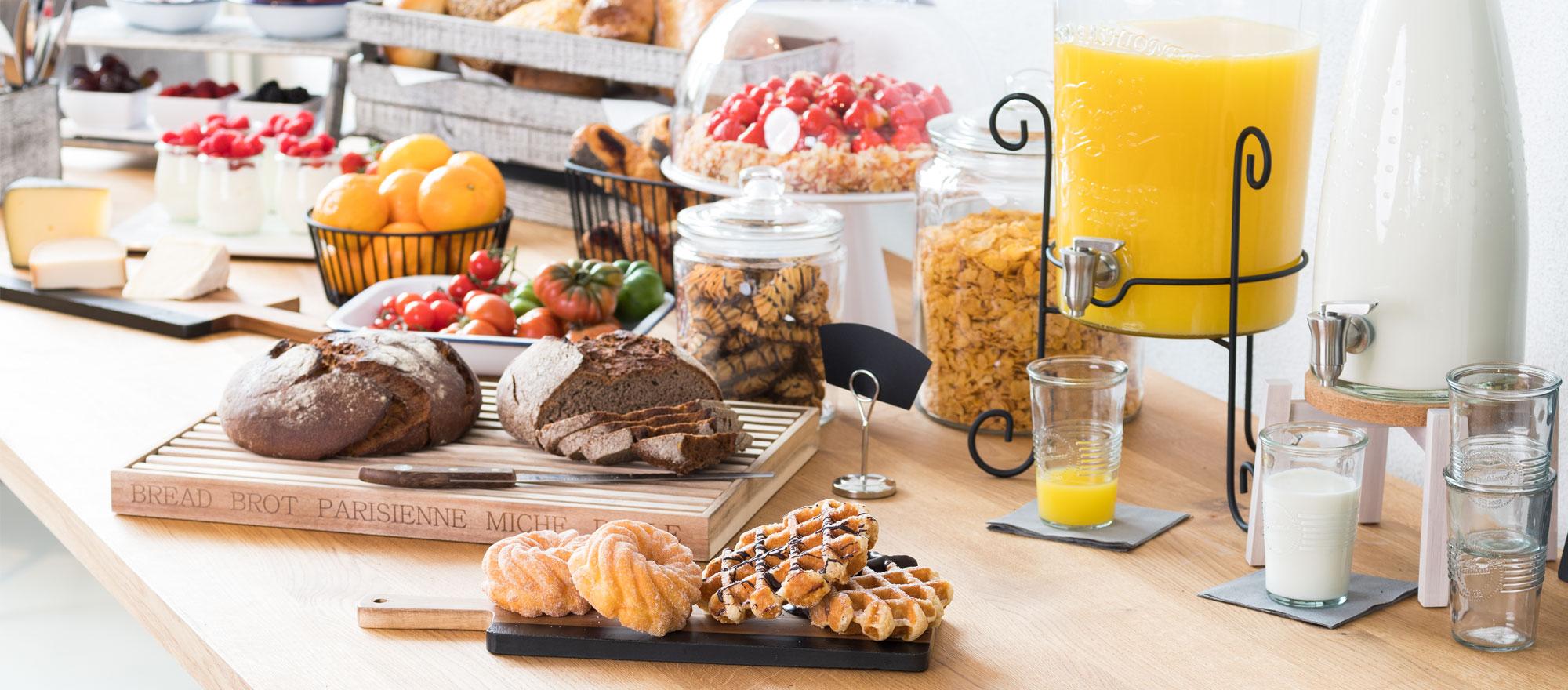 Buffet de petit déjeuner avec distributeur à jus d'orange et gobelets pour les professionnels de la restauration.