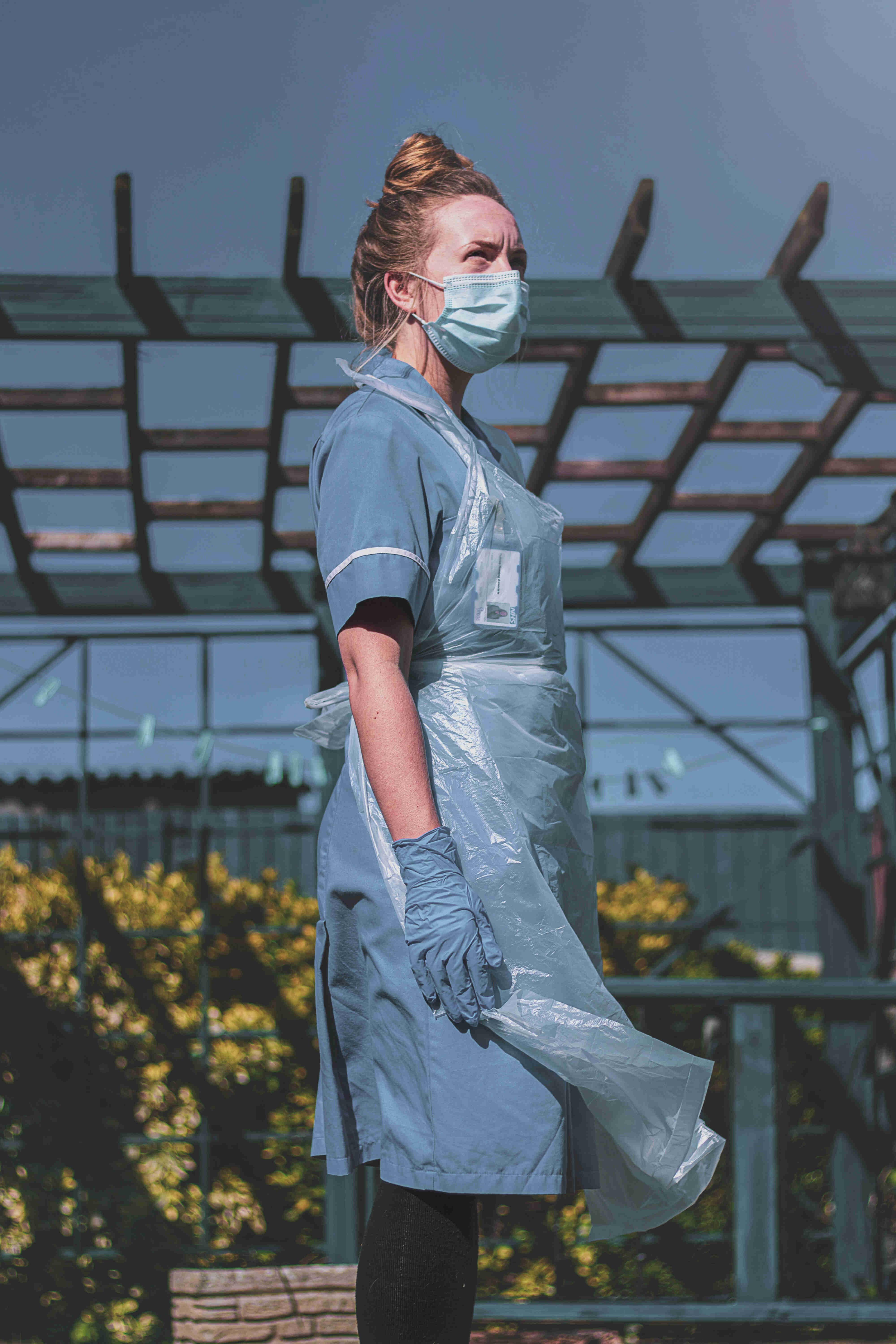 Photo d'une femme en extérieur portant un masque de protection et un tablier.