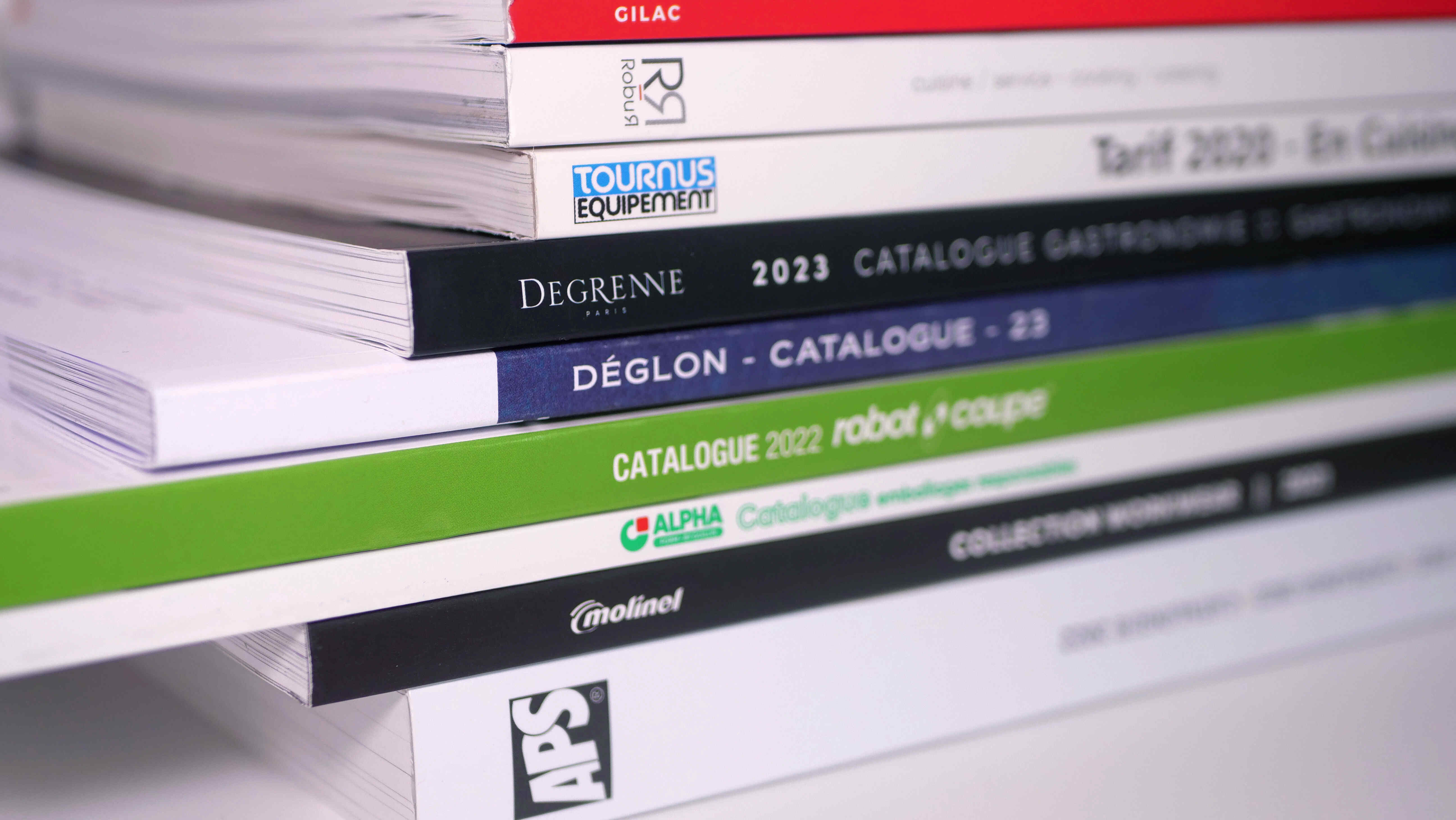 Pile de catalogues de produits professionnels pour la cuisine.