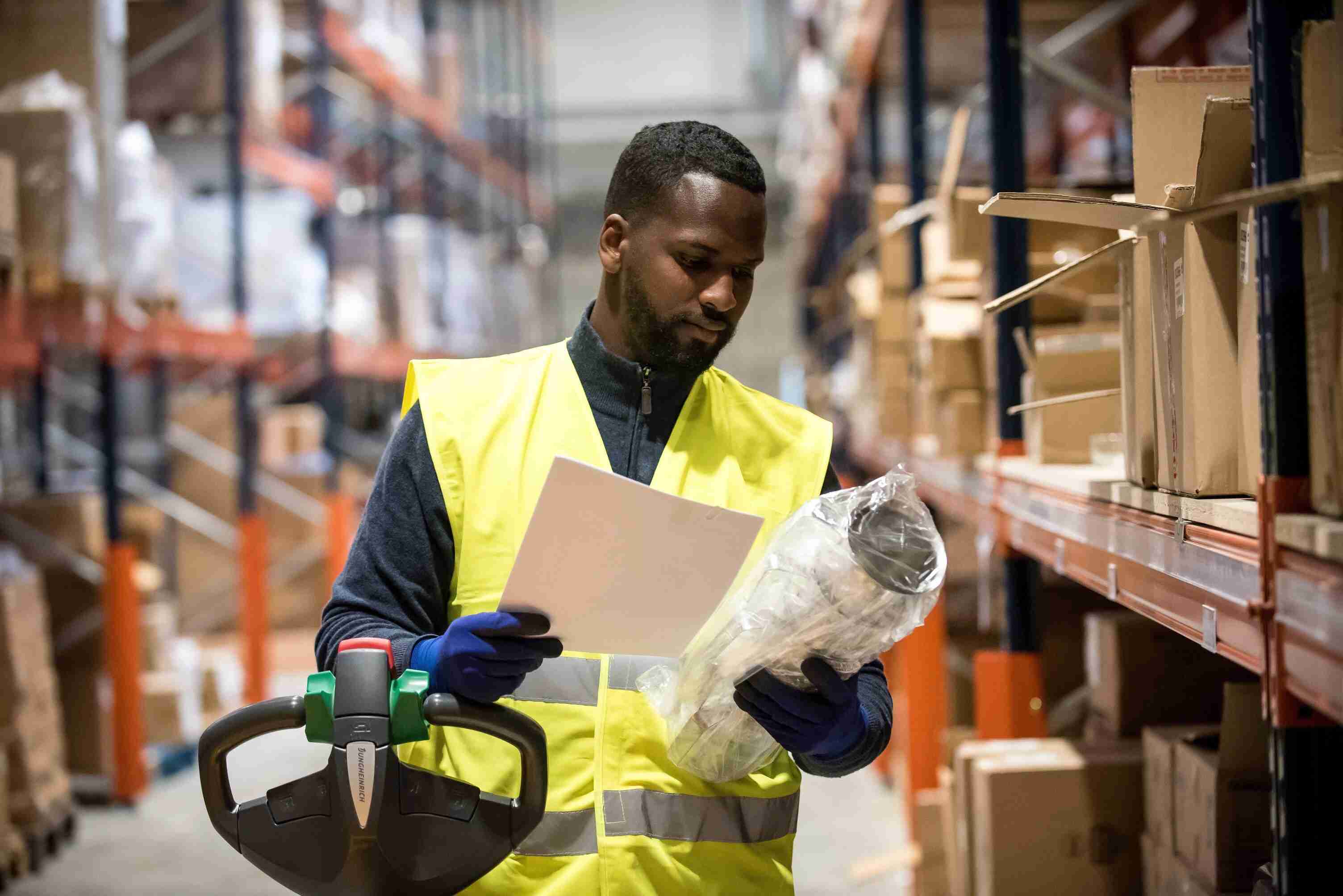 Employé d'entrepôt en train de vérifier qu'il a sélectionné le produit avec la bonne référence.