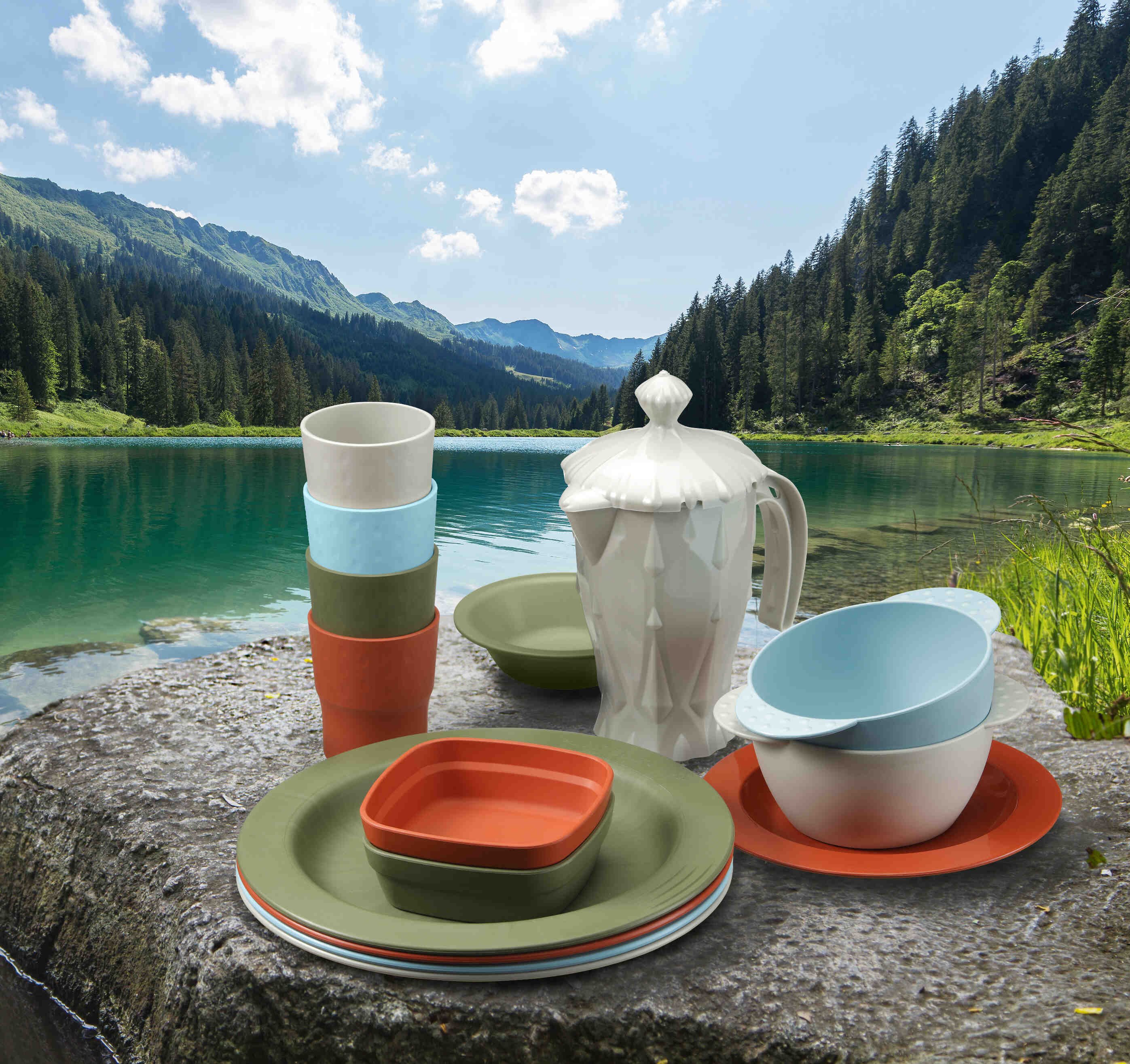Vaisselle (assiettes, bols, gobelets...) de couleurs verte, orange et bleue de la marque Saint-Romain.