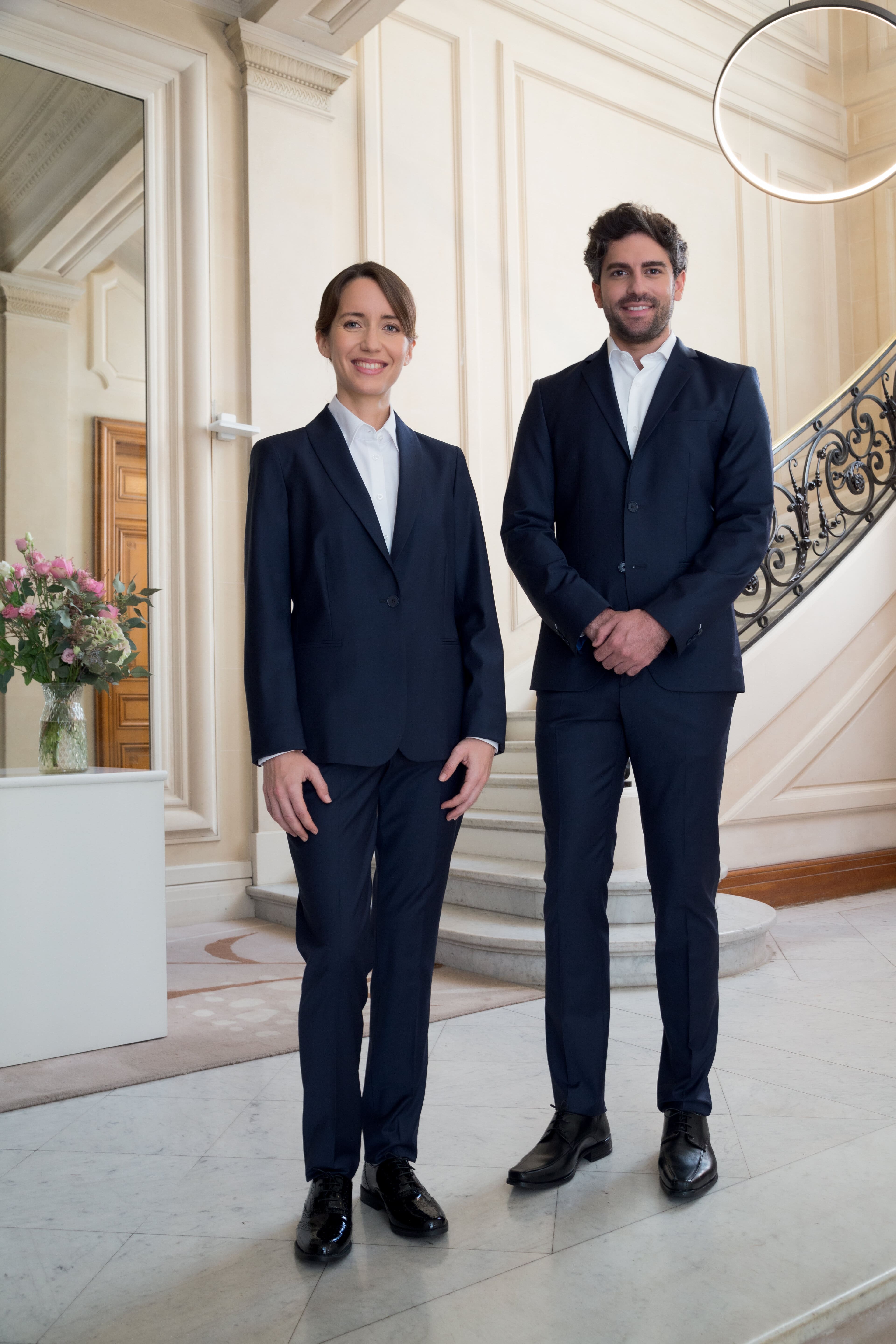 Un homme et une femme en tenue chic et professionnelle noire pour la restauration de la marque Robur.